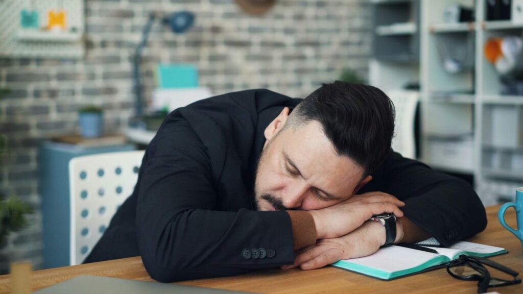 Exhausted man showing signs of workplace burnout